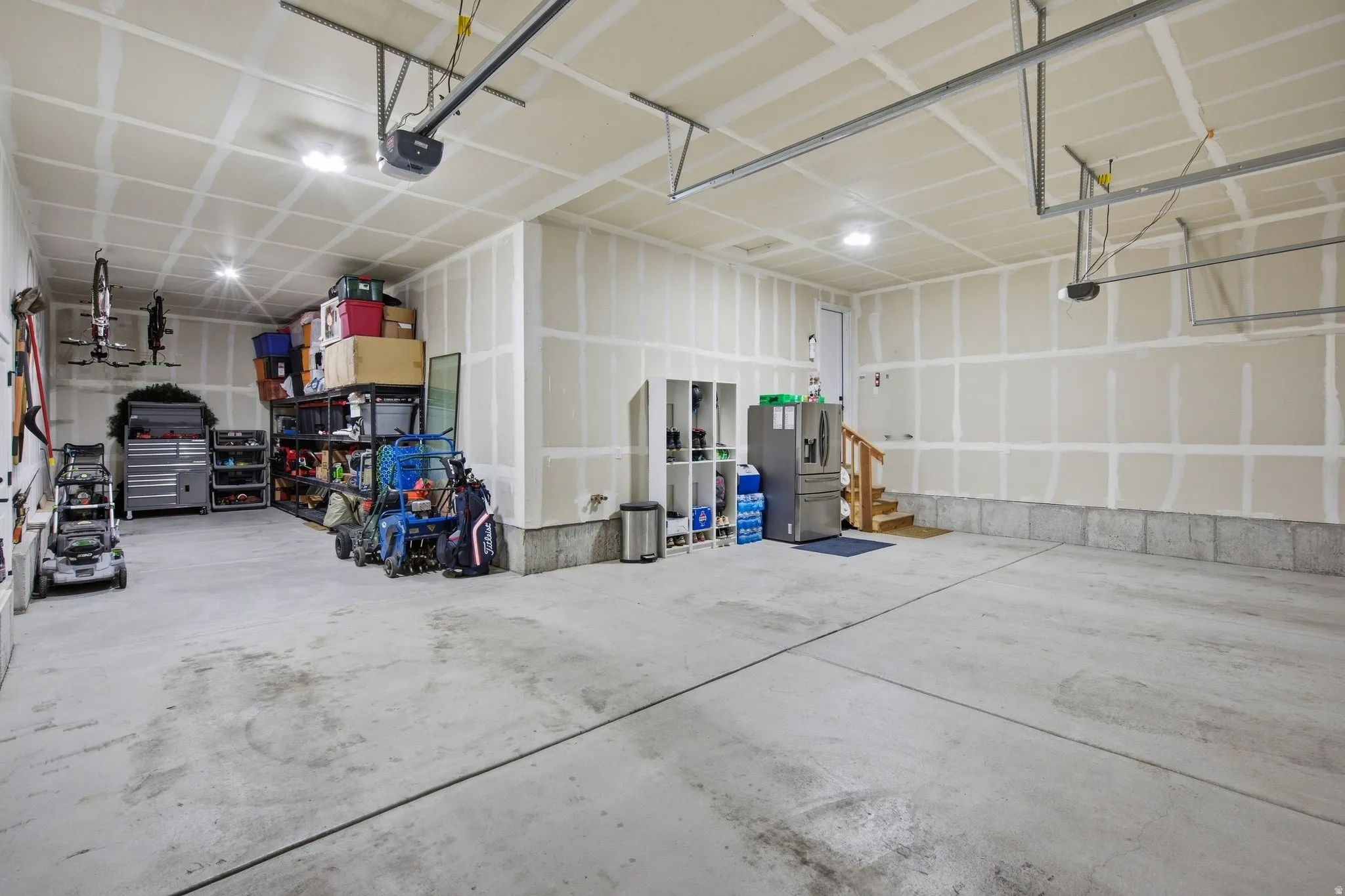 Spacious garage with concrete flooring, and overhead lighting.