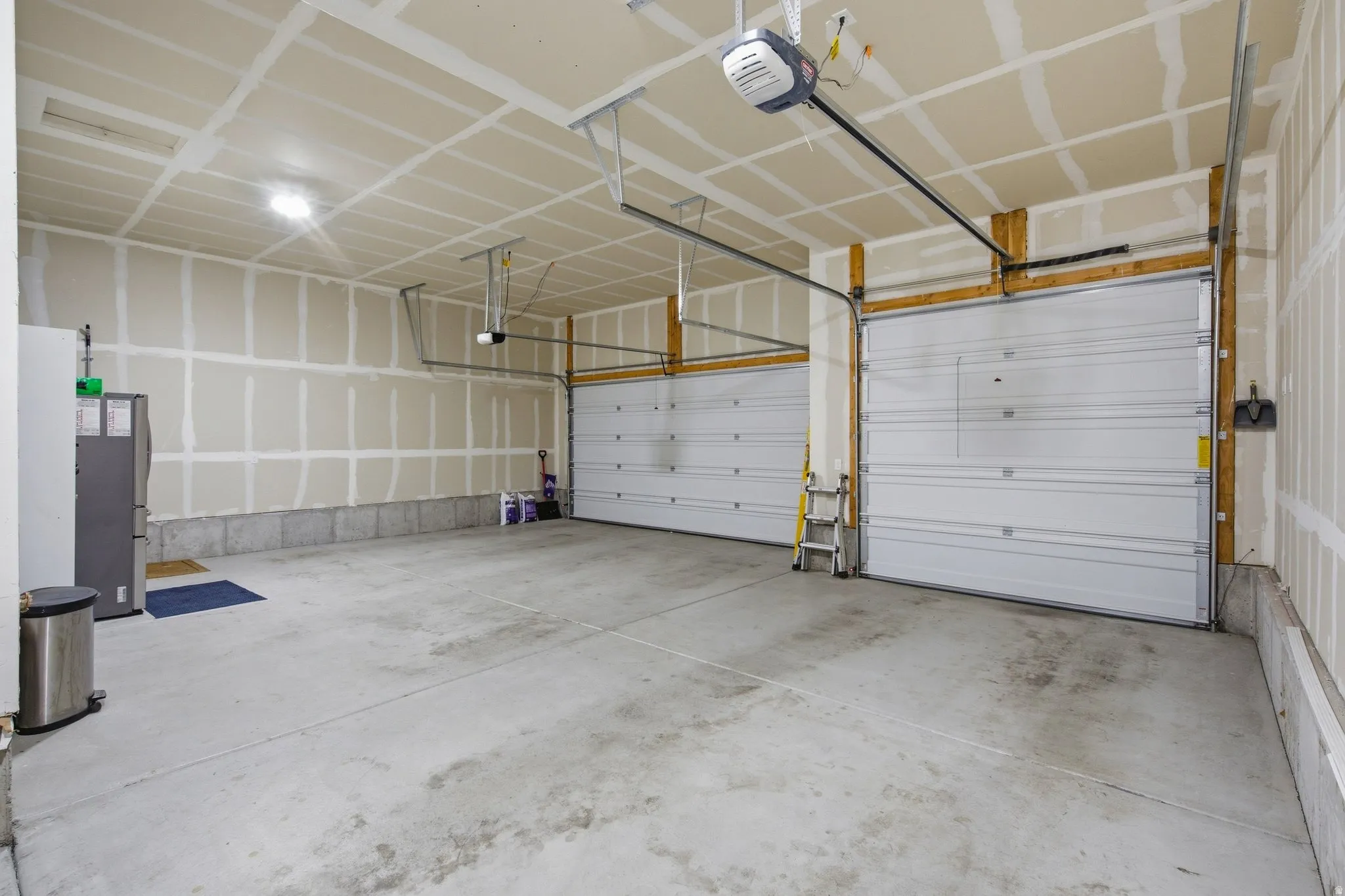 Overhead garage doors with automatic openers, and a concrete floor.