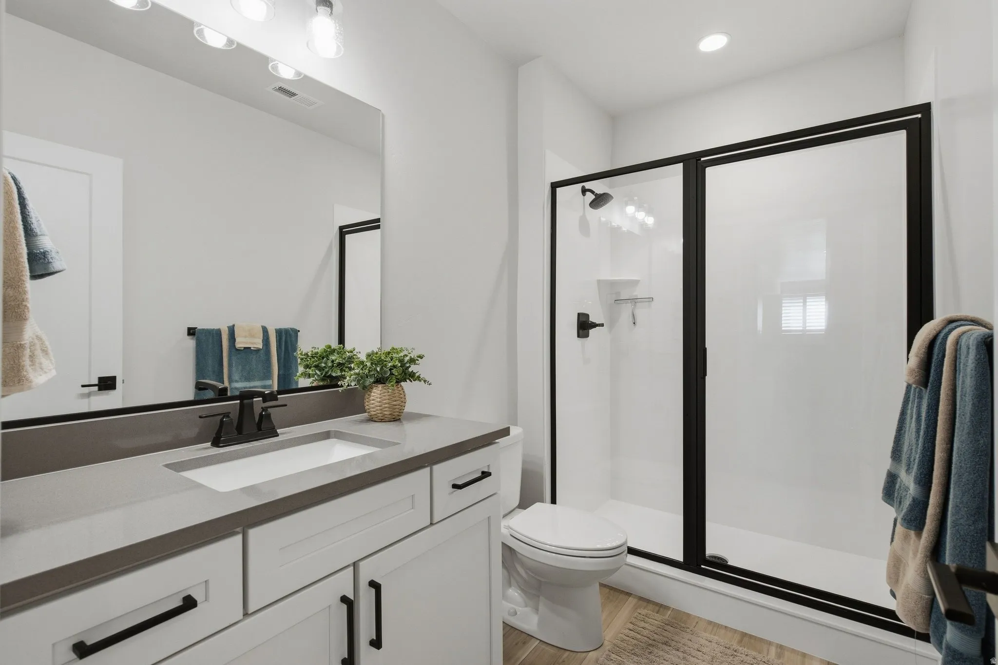 White vanity with matte black hardware, integrated sink, and grey countertop.