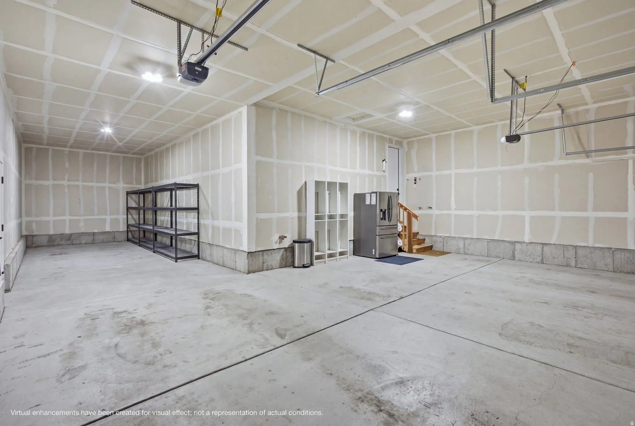 Spacious tandem, 4 car-garage, with concrete flooring, and built-in overhead lighting.