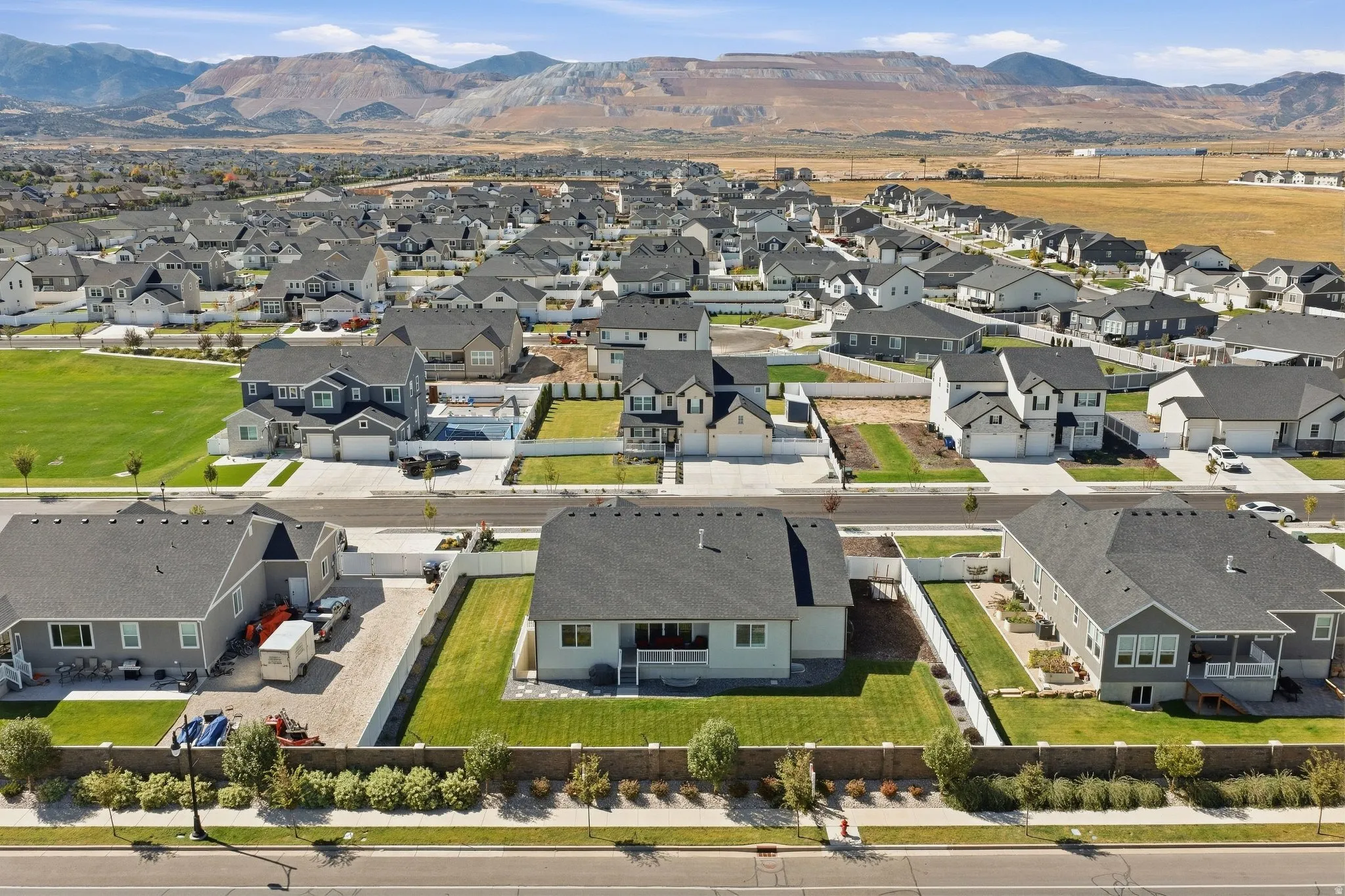 Community setting with mountain backdrop, residential properties, and open fields.
