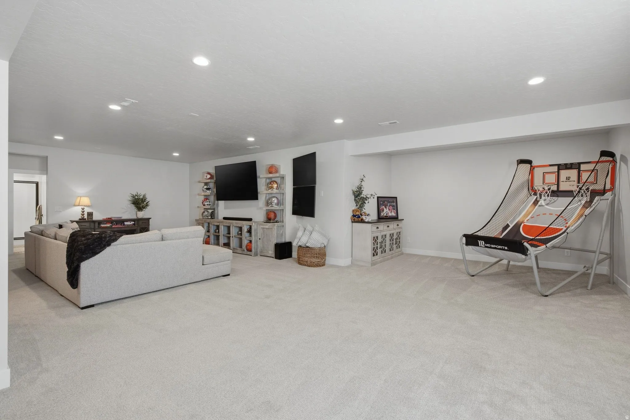 Open-concept living area with light-toned carpeting and recessed ceiling lighting