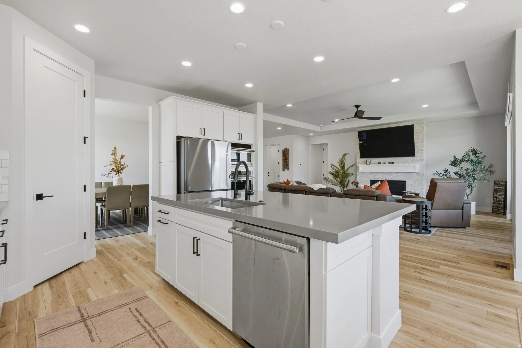 Kitchen island with undermount sink, stainless steel appliances, and white cabinetry.