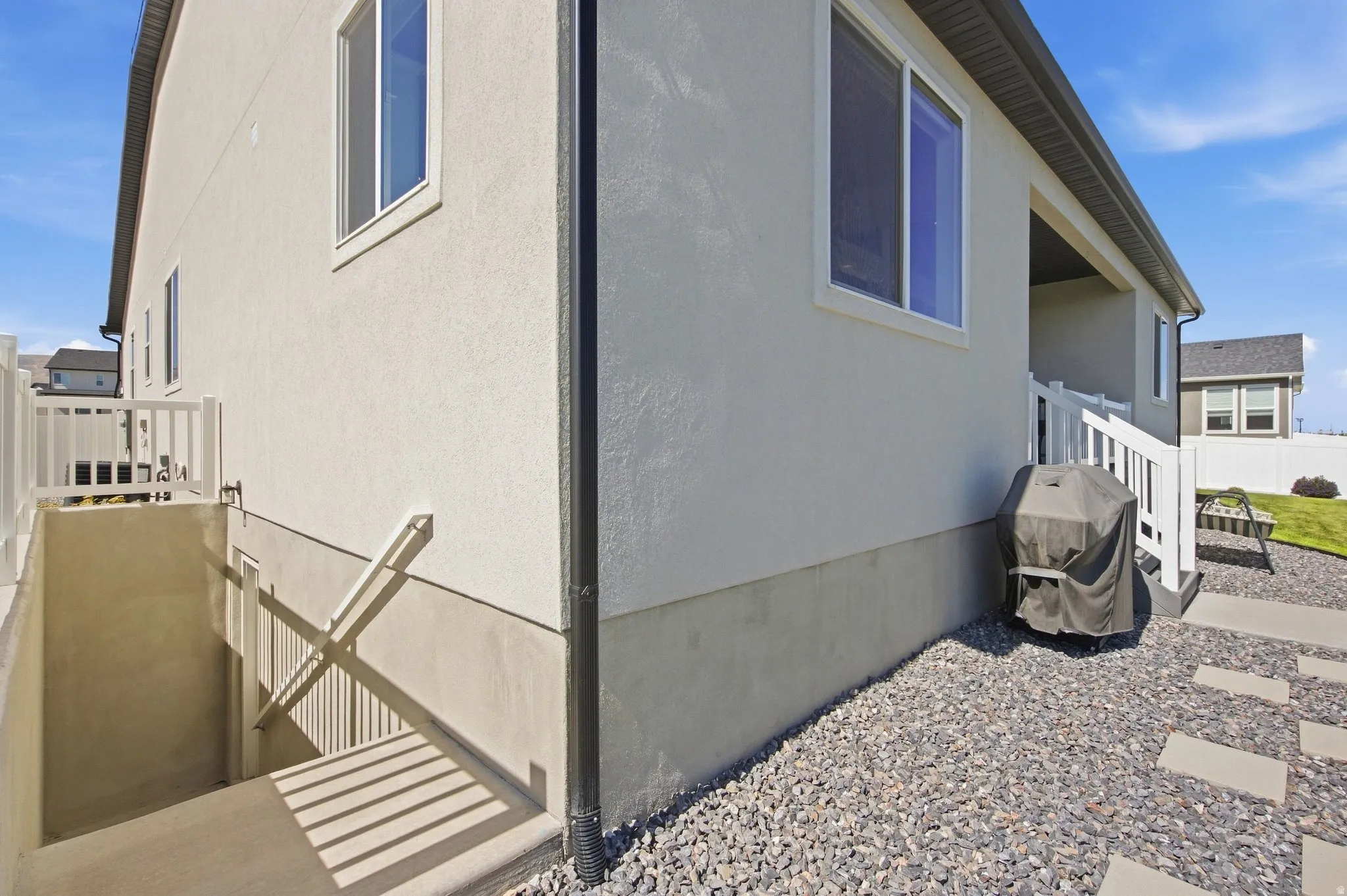 Stucco exterior with stairwell, leading to separate basement entrance.