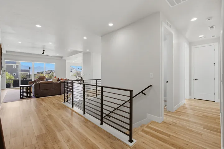 LVP flooring throughout, modern horizontal metal stair railing, recessed lighting, and expansive windows.