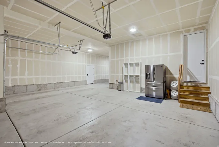 Concrete flooring, recessed lighting, white door, wooden stairs, concrete foundation.