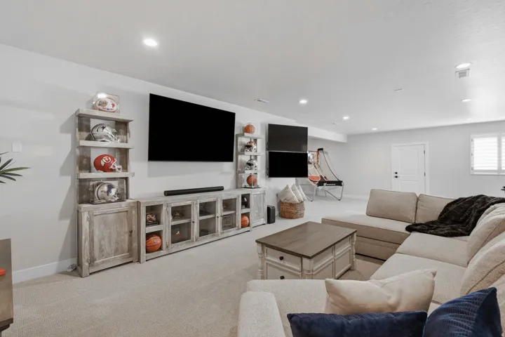 Recessed lighting, carpeted flooring, and window with white shutters.