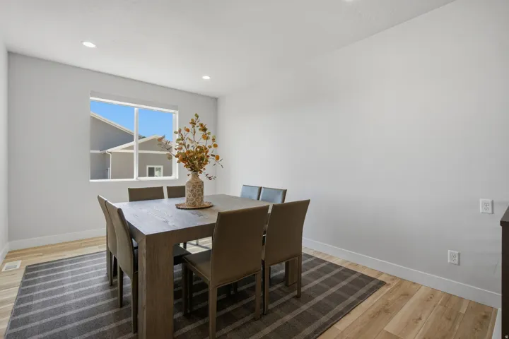 Recessed lighting illuminates the room with LVP wood-finish flooring.
