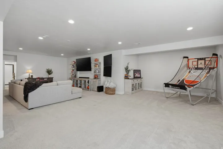 Open-concept living area with light-toned carpeting and recessed ceiling lighting