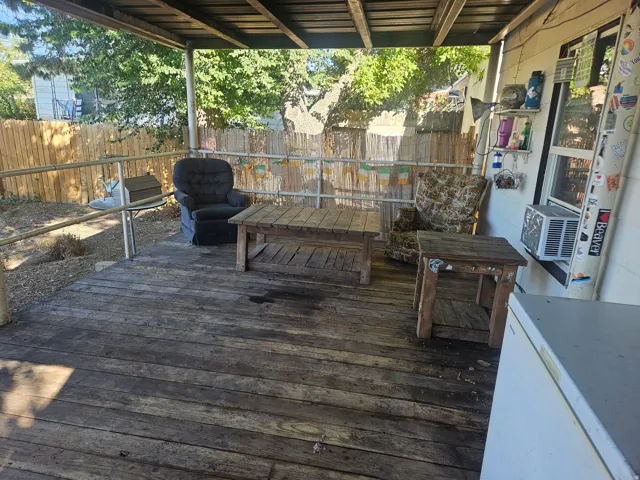 Covered outdoor deck with wood flooring and metal railings