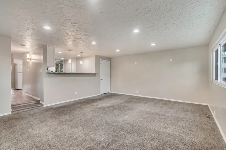 Recessed ceiling lighting, updated carpet flooring, multi-pane windows, built-in breakfast bar, and wall-mounted sconce lighting