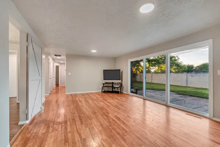 Wood-finish flooring, recessed lighting, and a sliding glass door