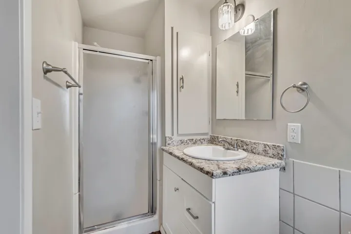White vanity with a laminate countertop, integrated sink, and brushed nickel fixtures