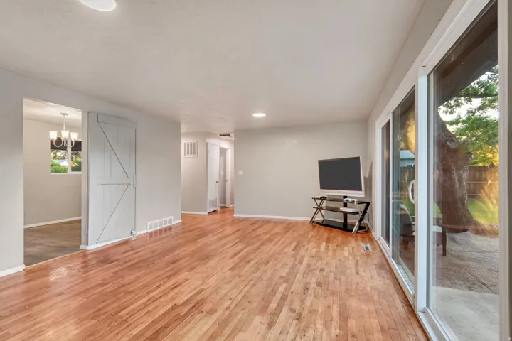 Hardwood flooring throughout, recessed lighting, sliding barn door, and glass sliding doors providing access to the exterior