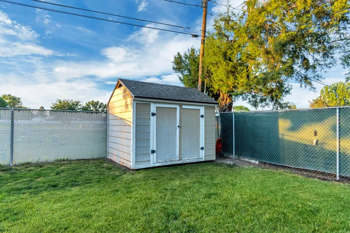 Storage shed with dual doors, shingled roof, and horizontal siding