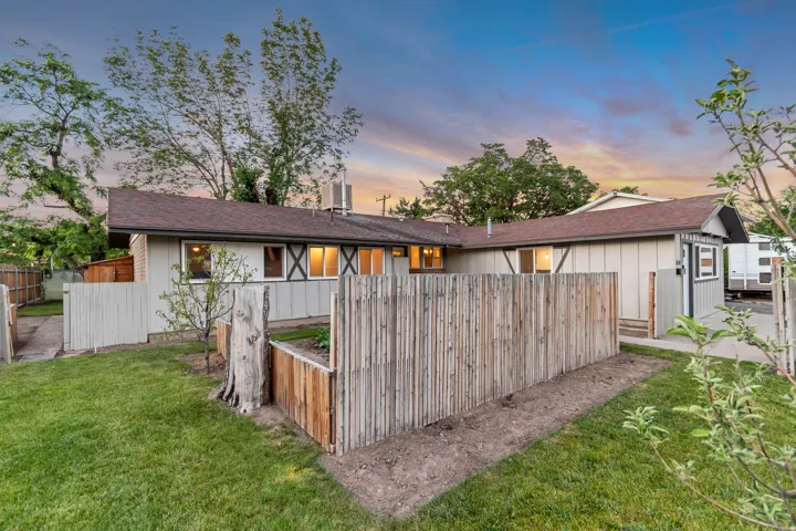 Manicured lawn, wood fencing, and a built-in raised garden bed