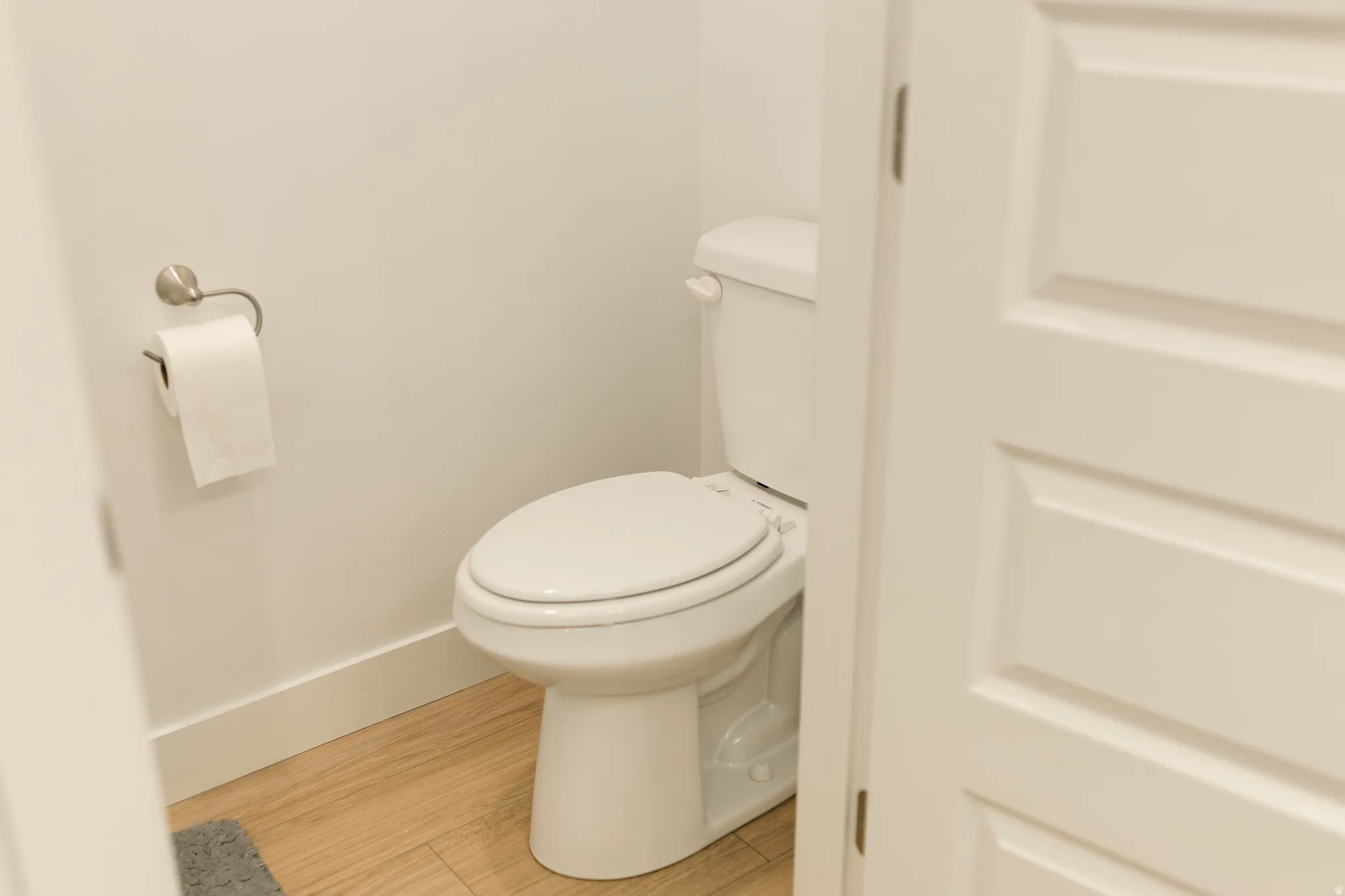 White paneled door, white walls, and wood-finish flooring