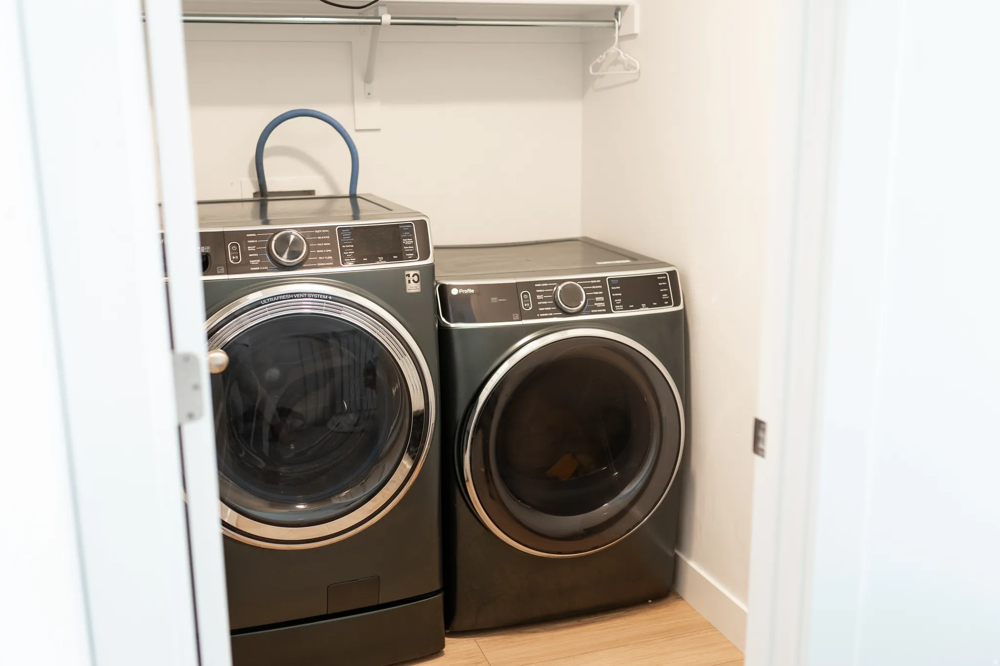 Built-in laundry closet with wood-finish flooring