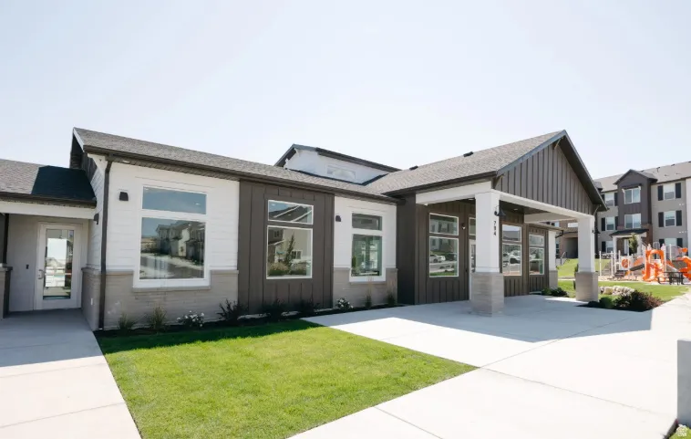 Modern exterior with white siding, dark vertical paneling, and stone accents