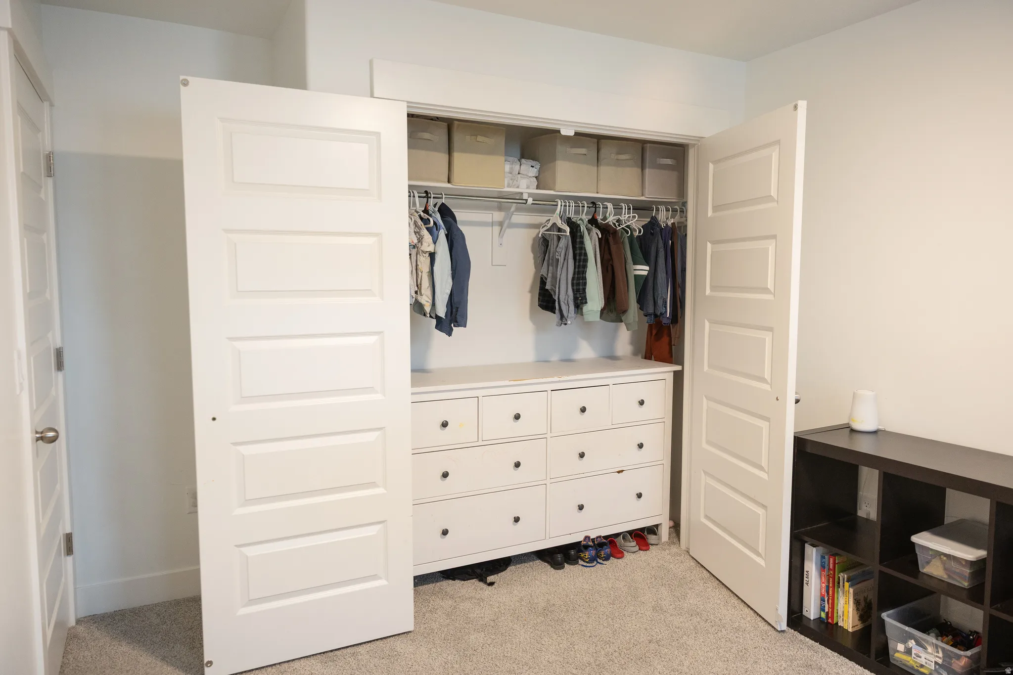 Closet featuring bi-fold doors, hanging rods, and built-in drawer storage
