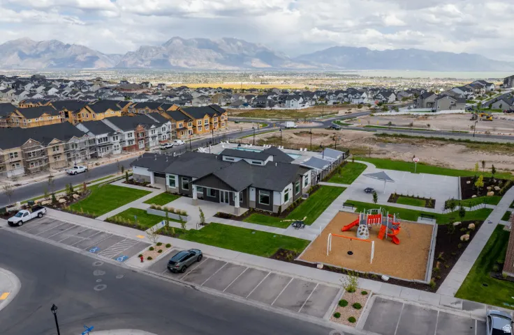 Community amenities featuring a modern recreation center, outdoor swimming pool, and playground area with a shaded seating zone