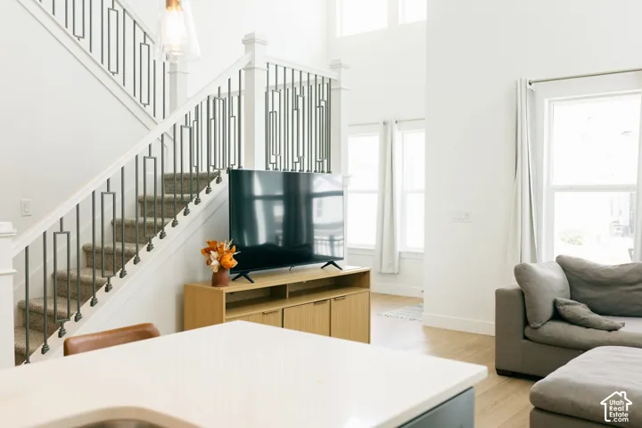 Two-story ceilings, large windows, wood-finish flooring, and a staircase with metal balusters
