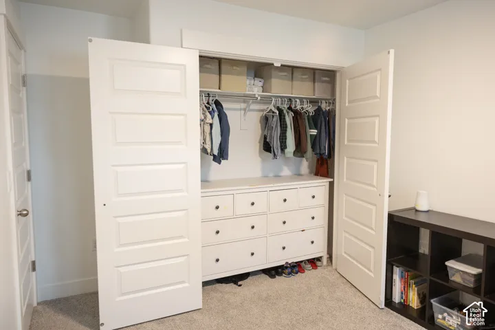 Closet featuring bi-fold doors, hanging rods, and built-in drawer storage
