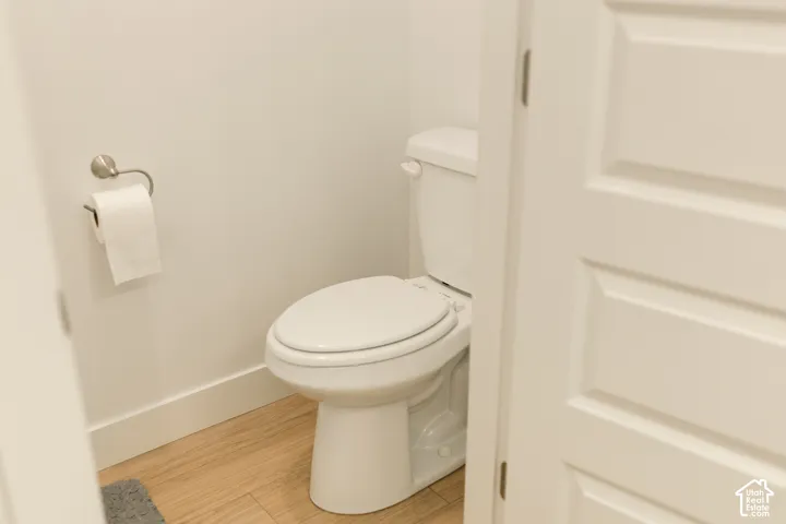 White paneled door, white walls, and wood-finish flooring