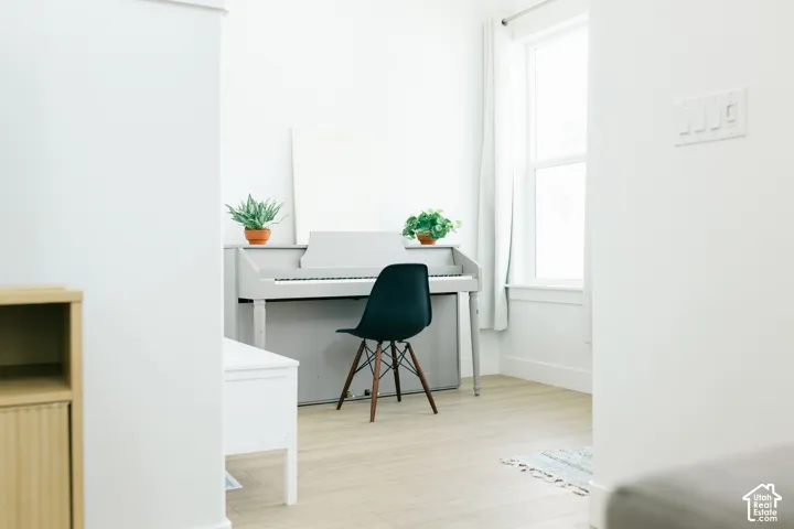 Light wood-finish flooring, white walls, and a large window with white trim