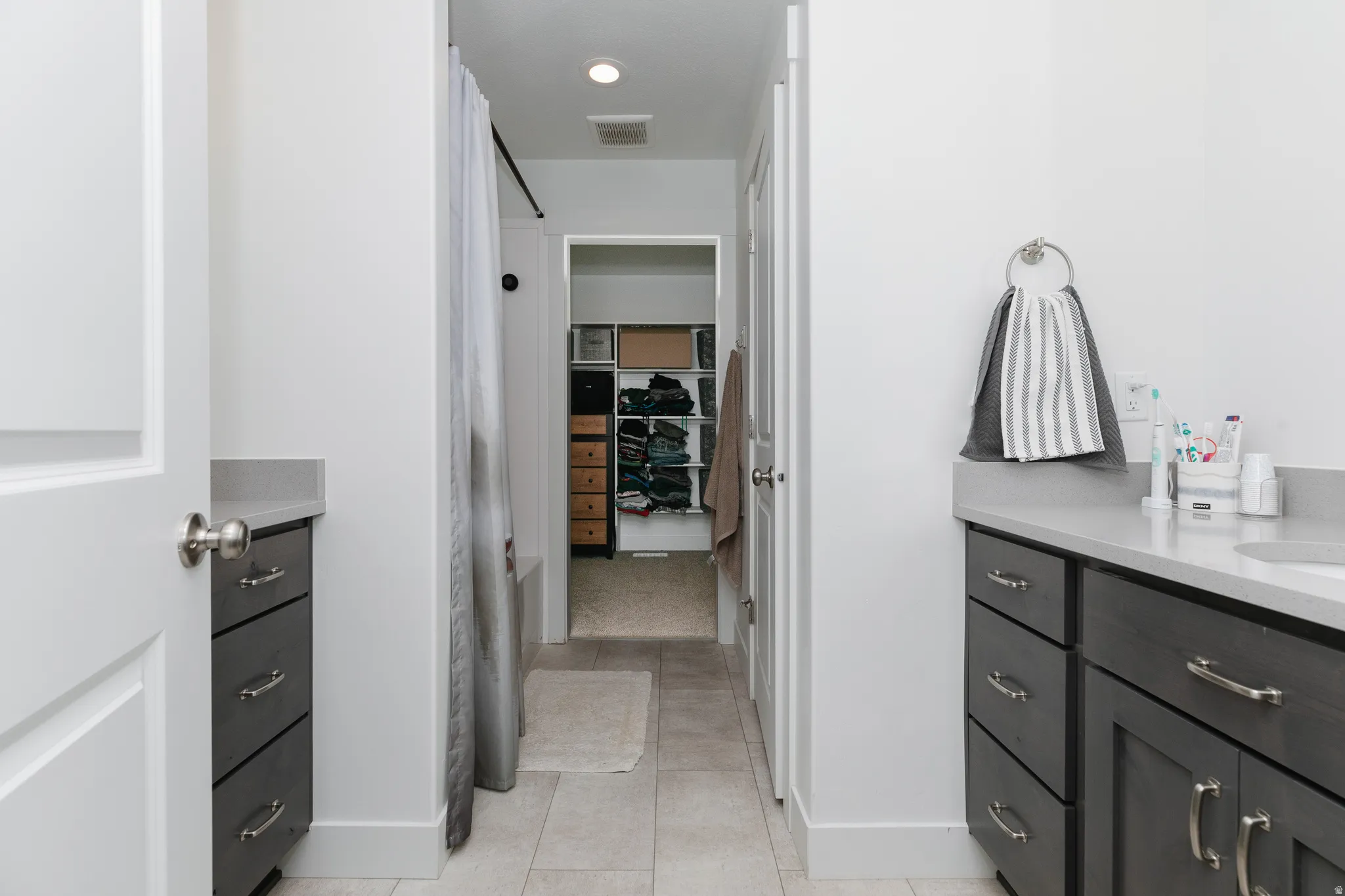 Dual vanity with dark wood-finish cabinetry and light countertops