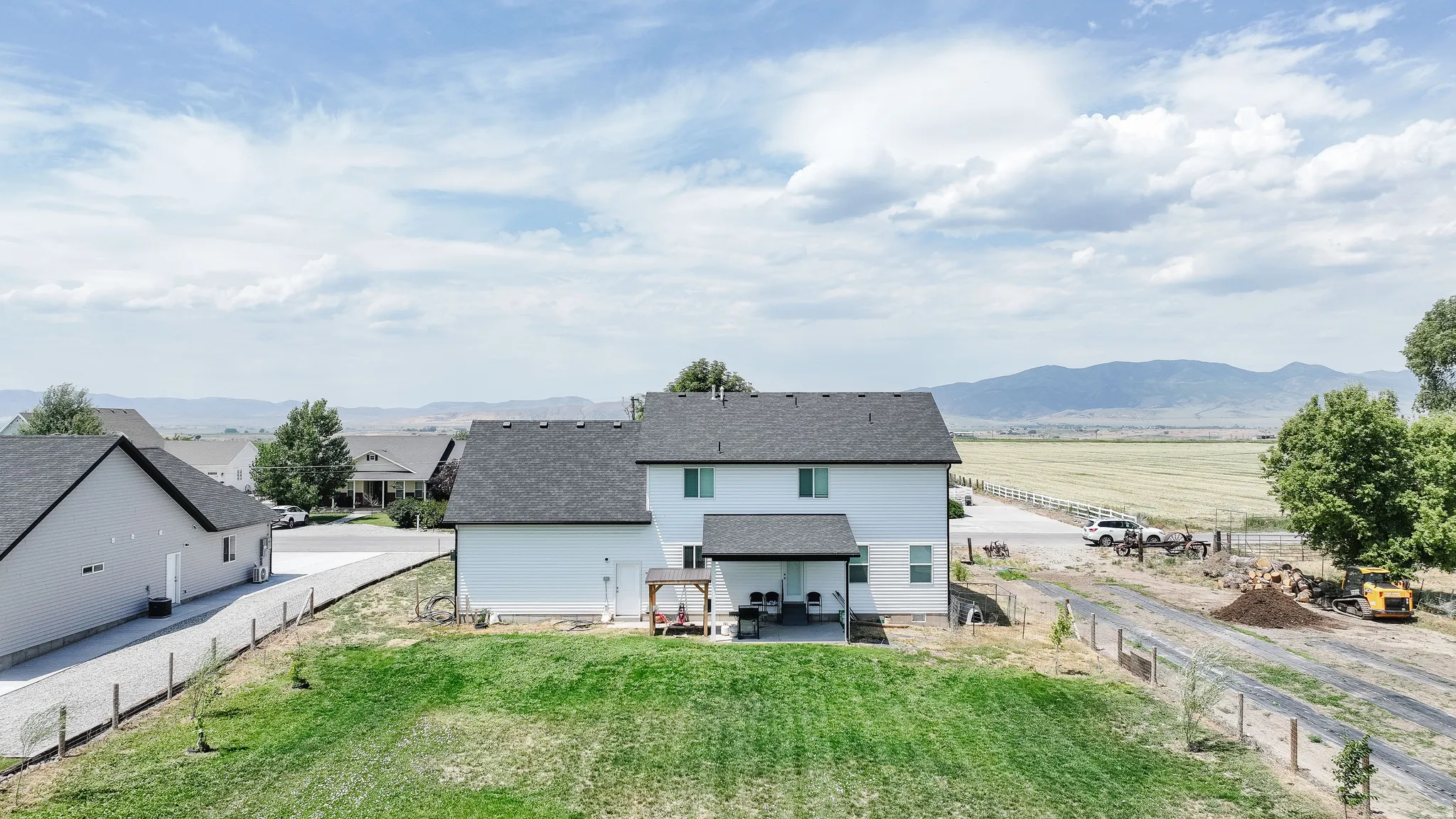 Expansive backyard with a covered patio, detached garage, and distant mountain scenery