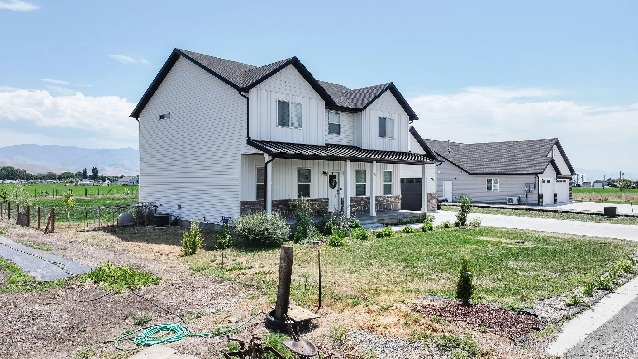 Two-story residence featuring white siding and a dark shingle roof