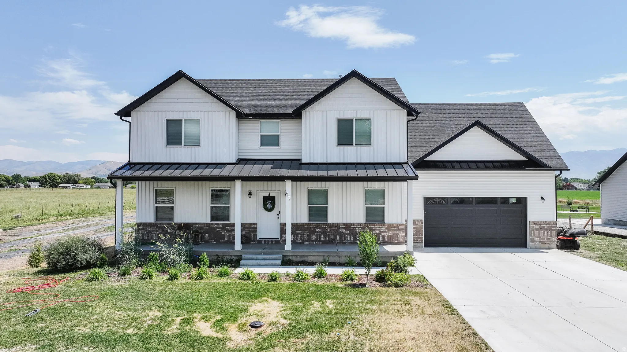 Two-story residence featuring white vertical siding and dark trim