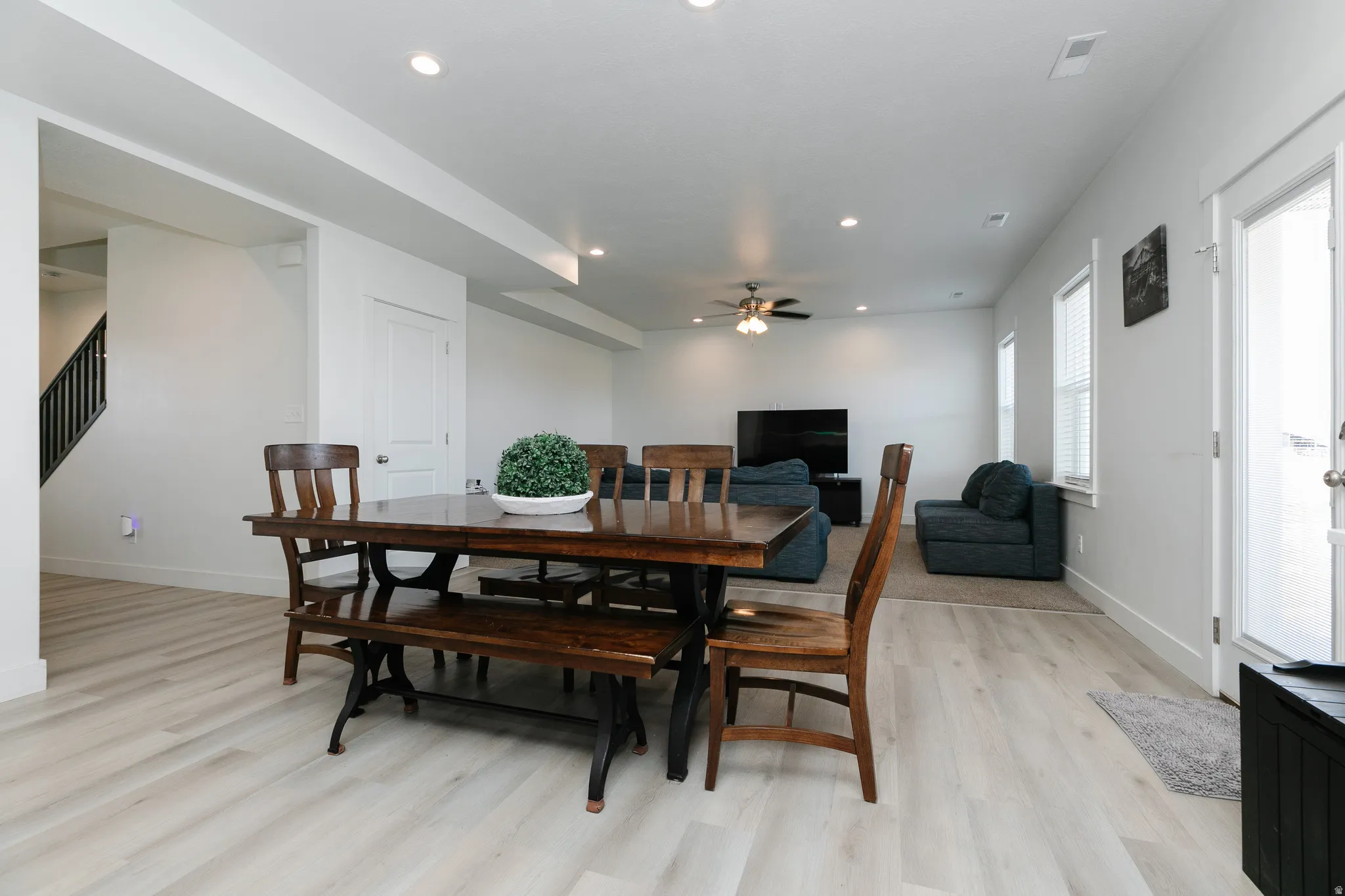 Open-concept living area with wood-finish flooring, recessed lighting, and a ceiling fan