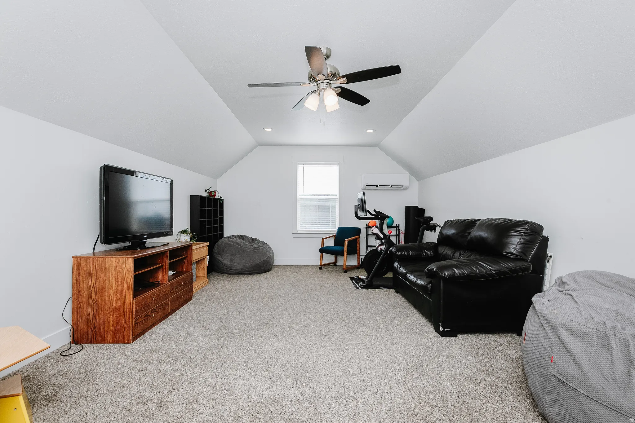 Carpeted attic space featuring sloped ceilings, recessed lighting, and a ceiling fan