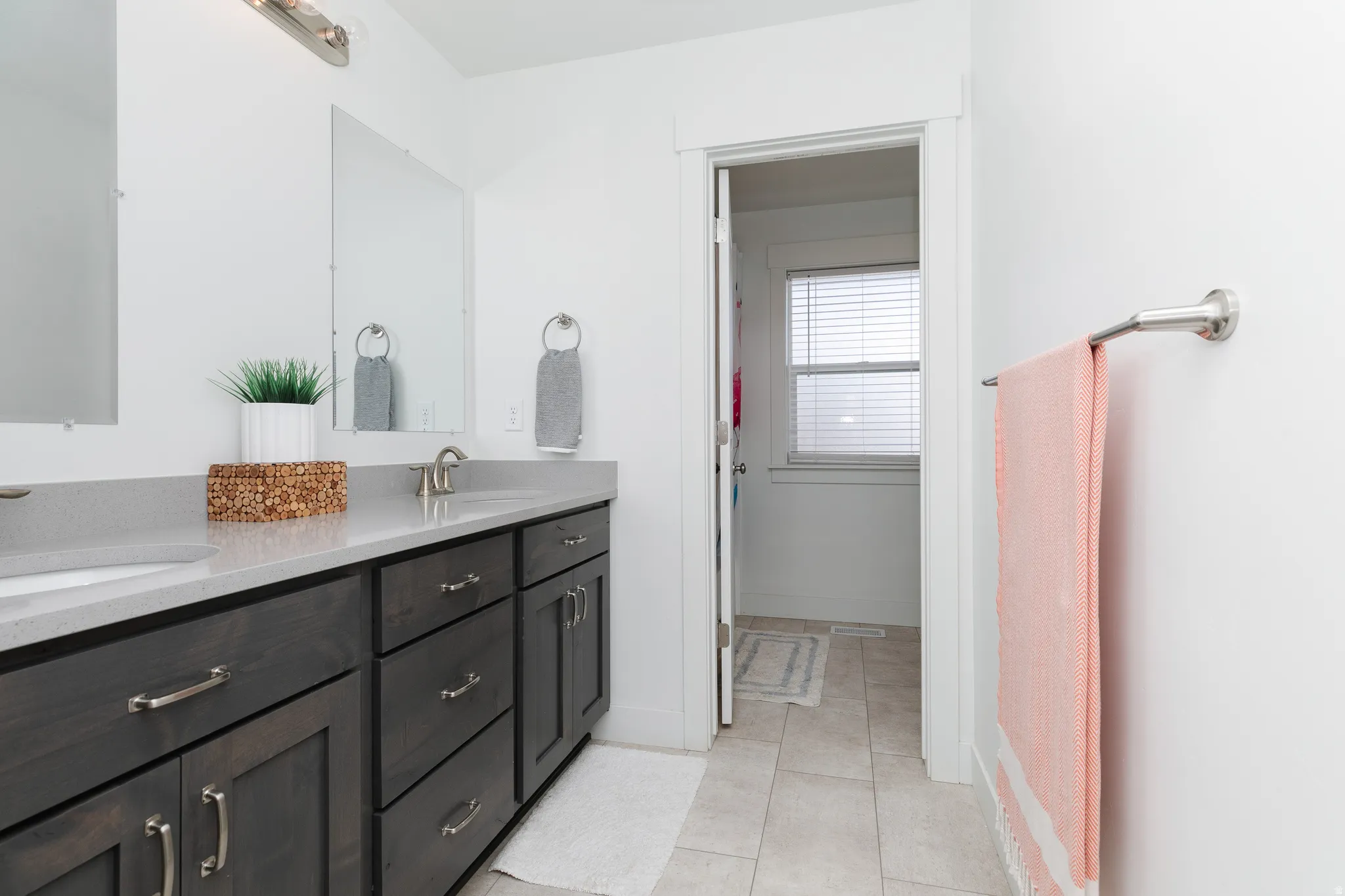 Dual vanity with dark wood-finish cabinetry and light countertops