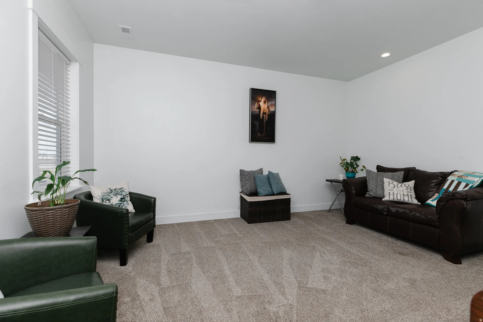 Recessed lighting illuminates the carpeted flooring and white walls