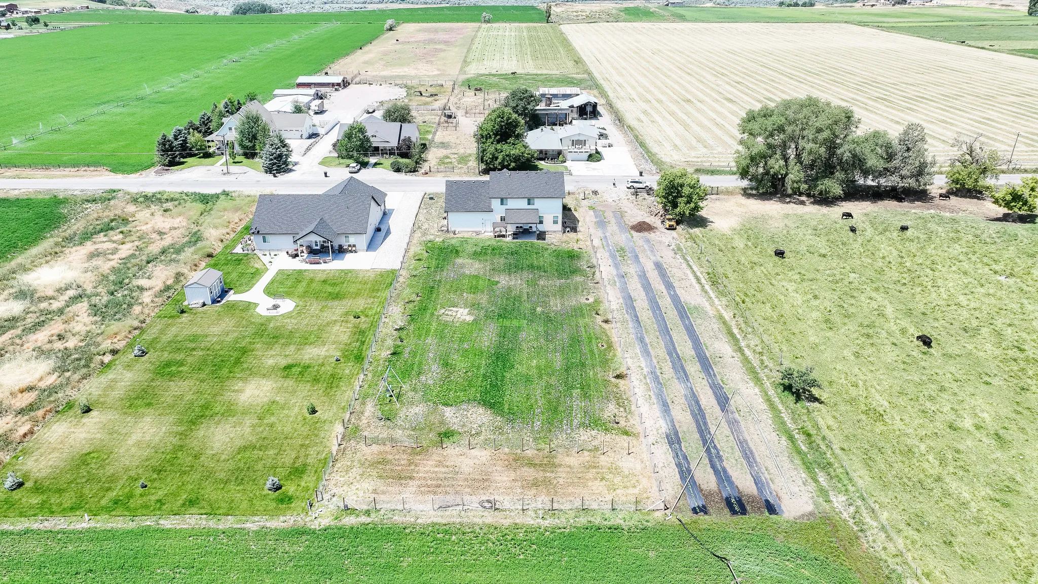 Expansive property with a white exterior residence, detached shed, and concrete driveway
