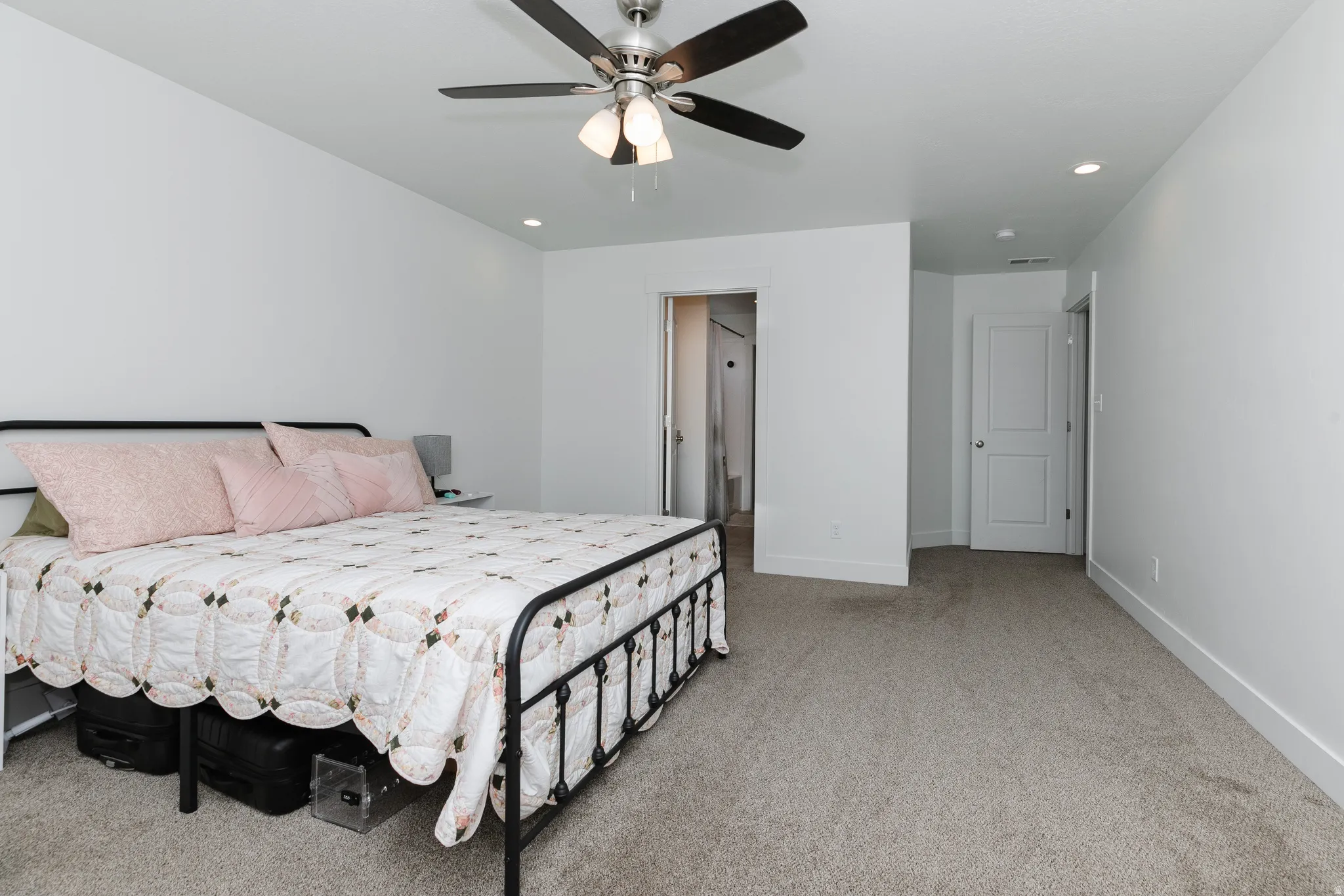 Neutral-toned carpeting, white painted walls, ceiling fan with integrated lighting, recessed ceiling lighting, and white interior doors
