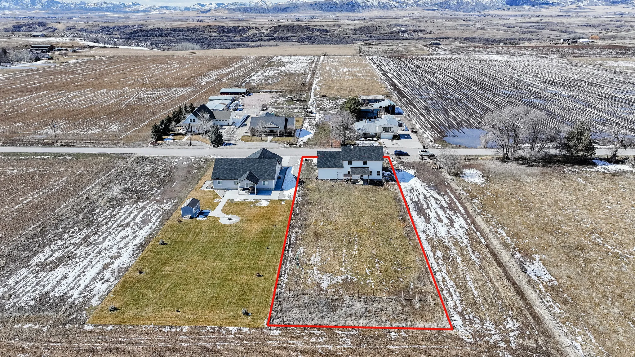 Expansive lot with a two-story residence featuring a white exterior, dark roof, and attached garage