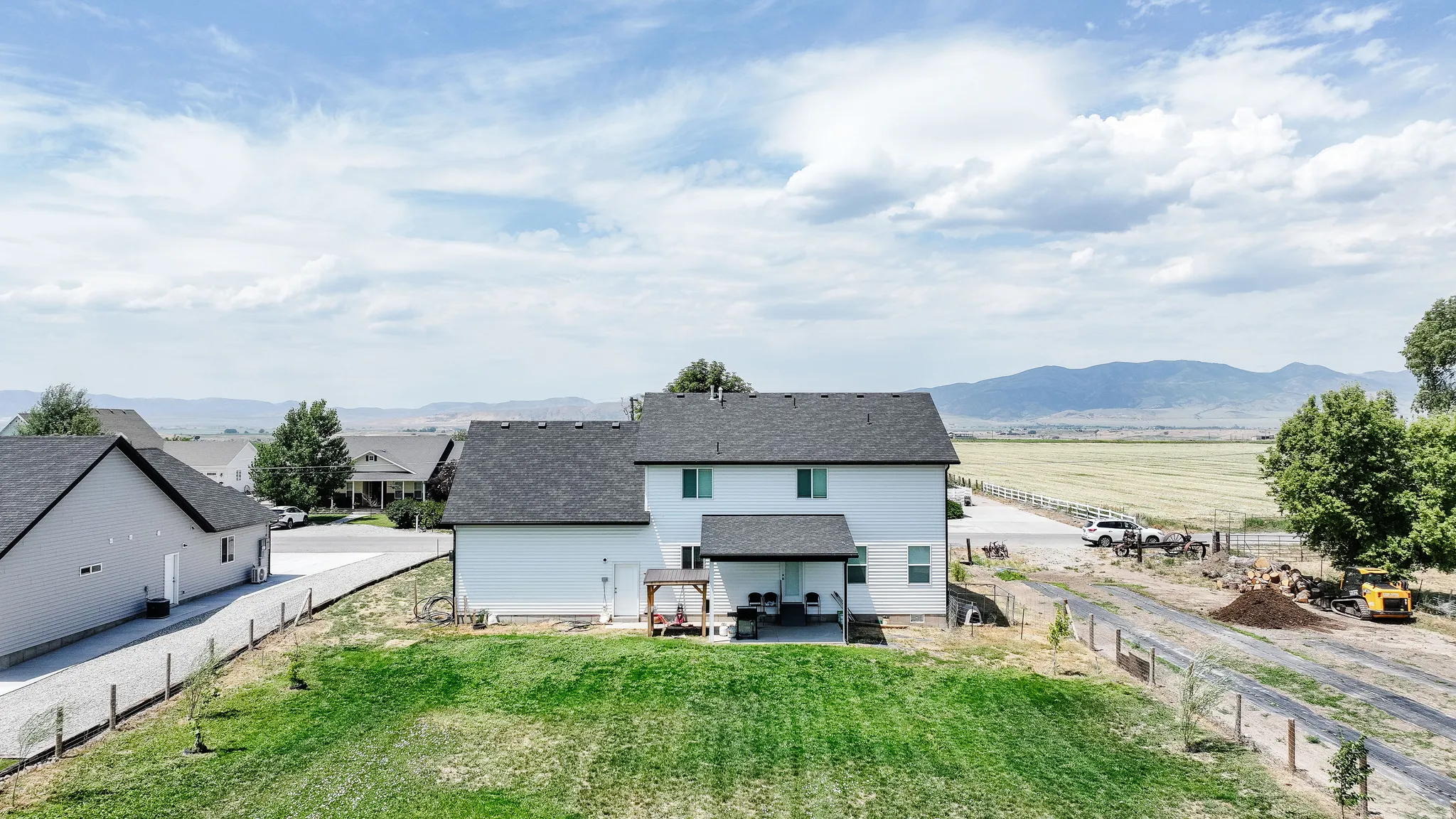Expansive lot featuring a green lawn, covered patio, and a separate detached structure