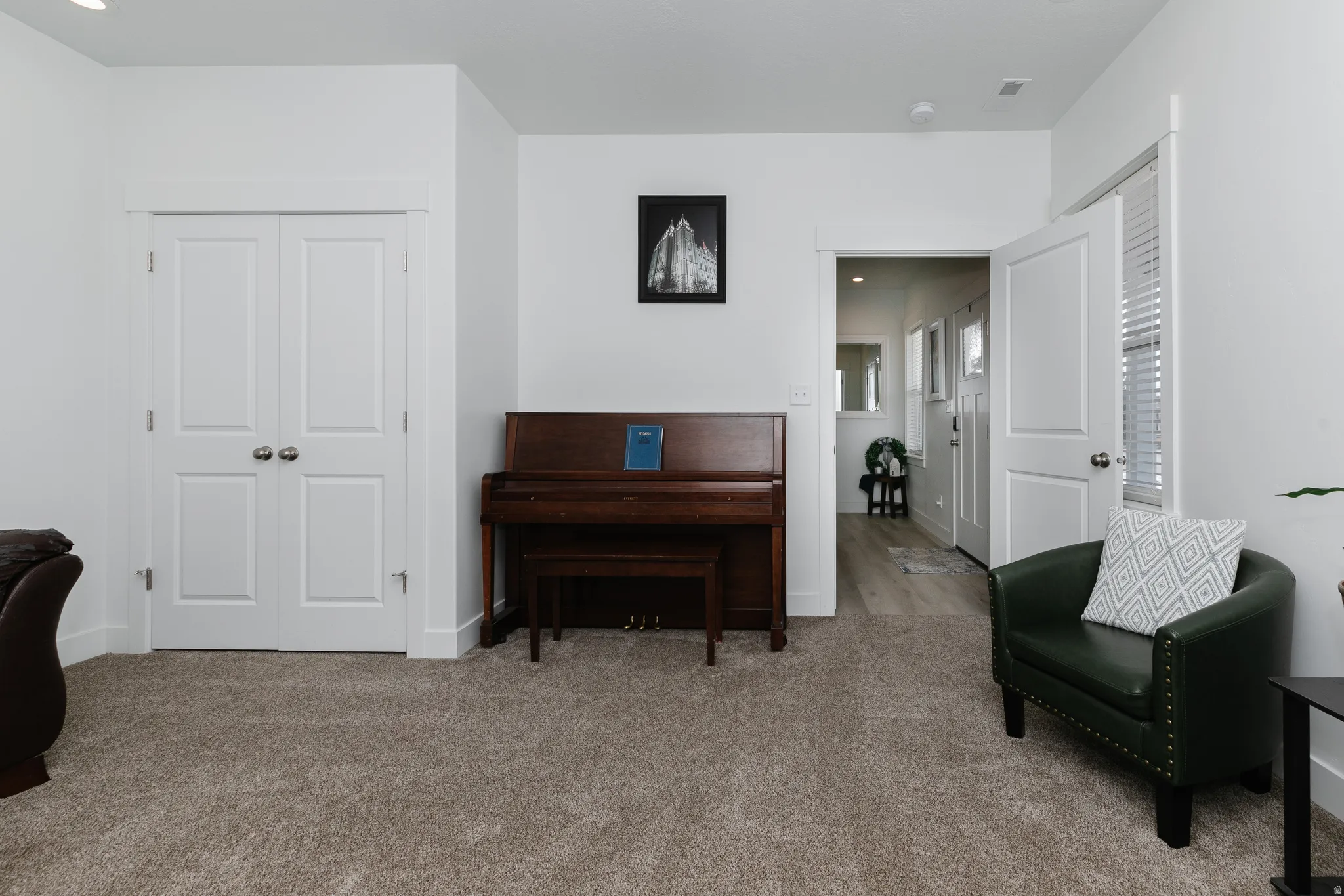 Neutral-toned wall-to-wall carpeting, white interior walls, and recessed lighting