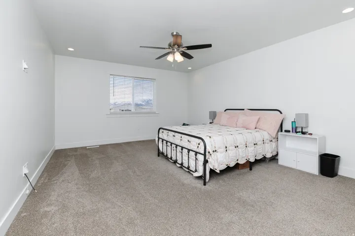 Recessed lighting, ceiling fan with integrated light, horizontal blinds, and neutral carpeting