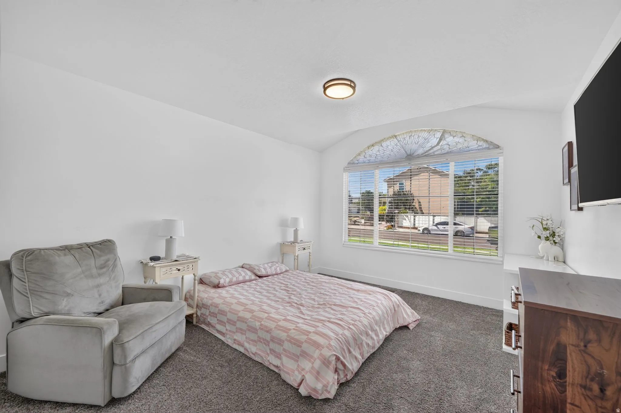 Arched picture window with blinds, recessed ceiling light fixture, and textured carpeting