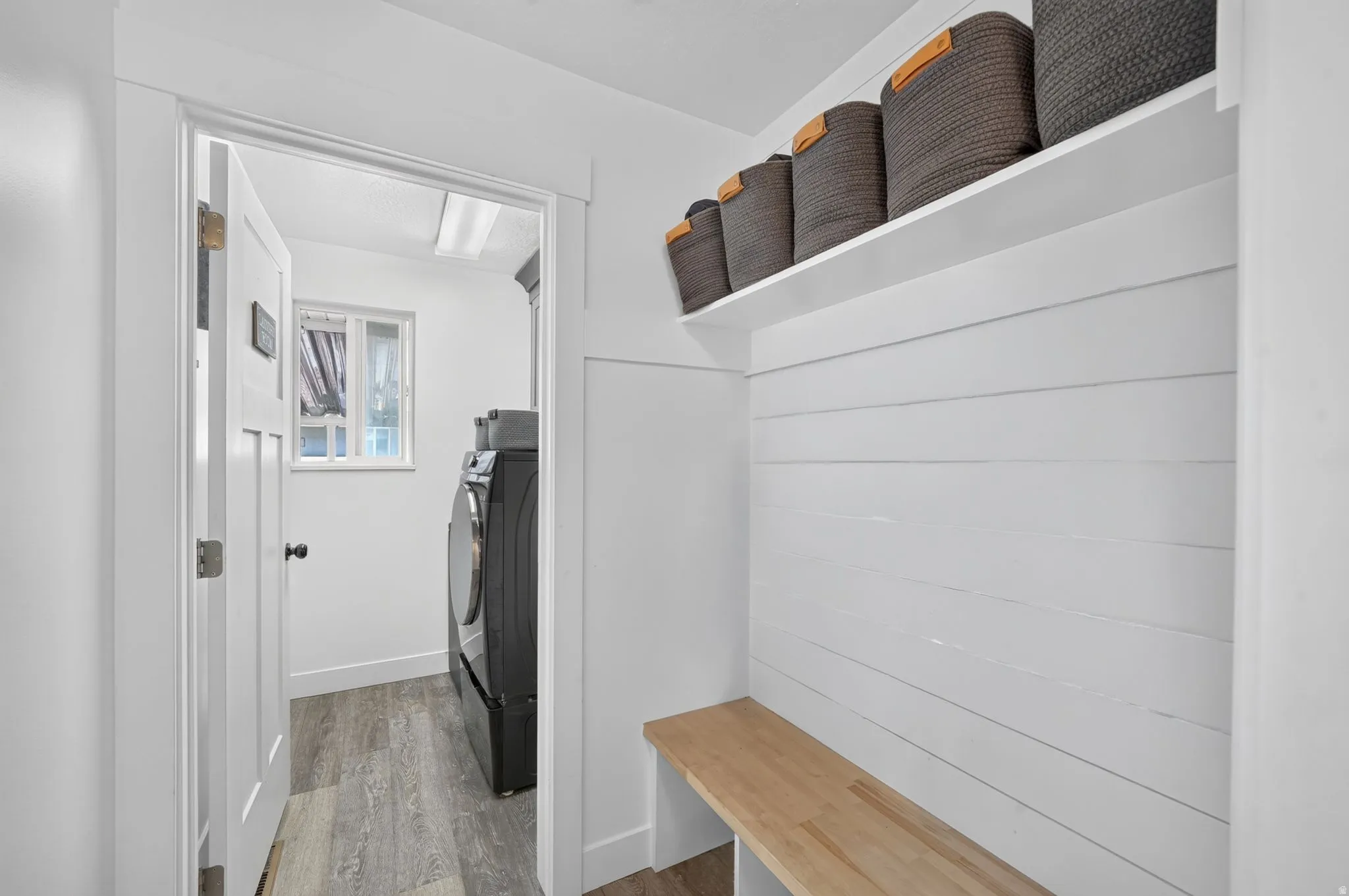 Entryway featuring a built-in bench, shiplap wall detail, and a storage shelf