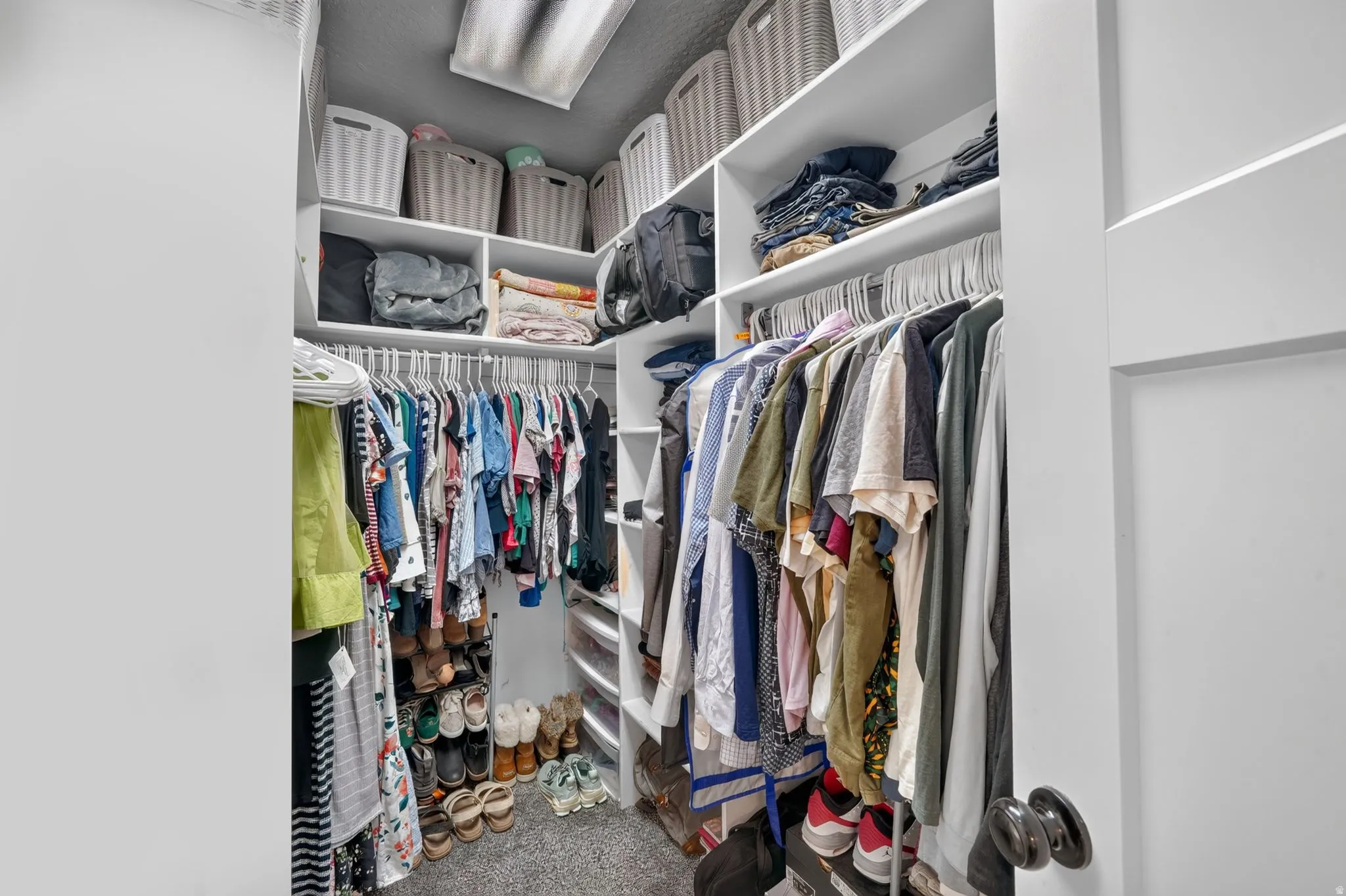 Built-in custom shelving, multiple hanging rods, corner shelving unit, and recessed ceiling light