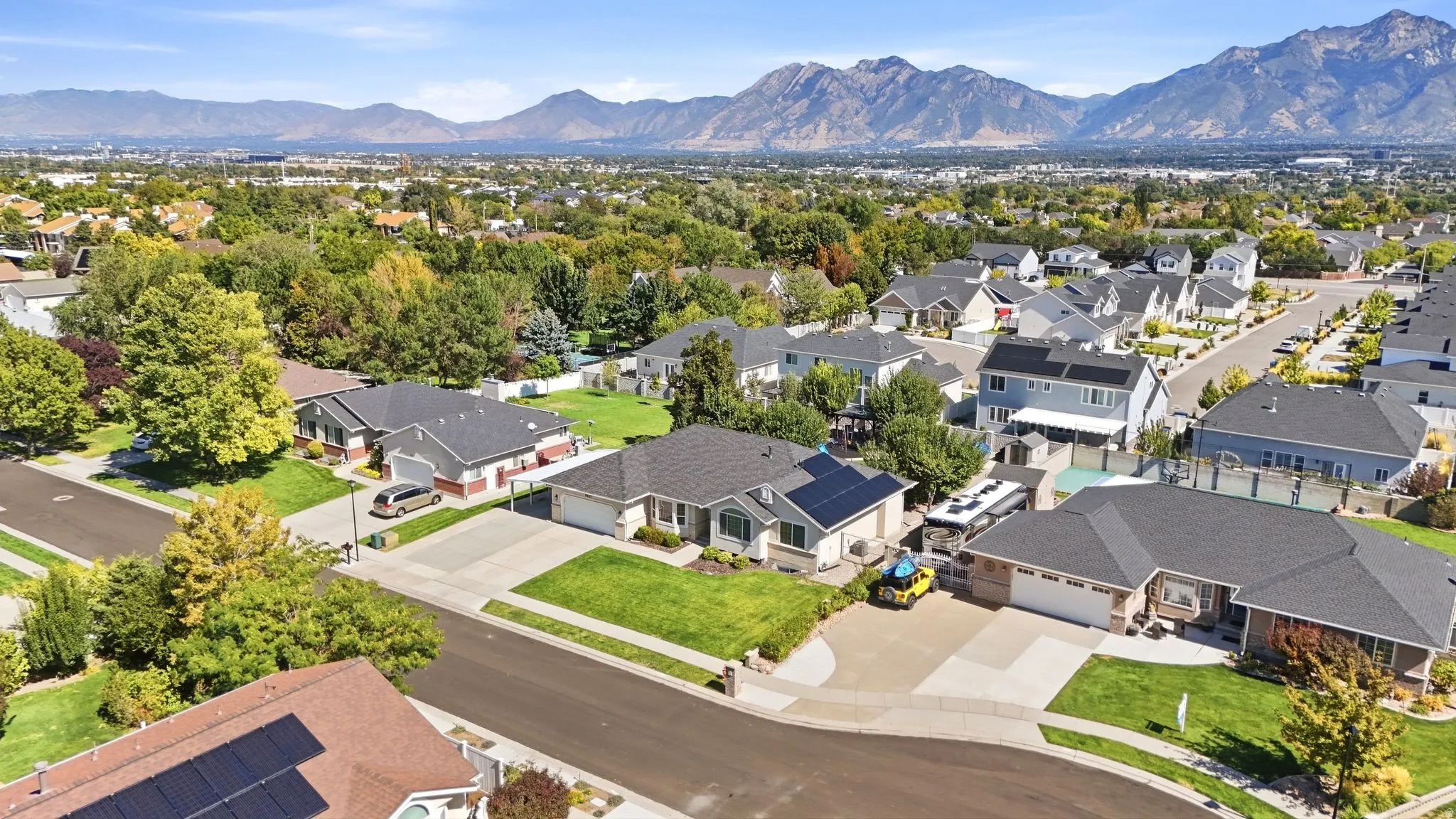 Neighborhood setting with mature trees and mountain scenery