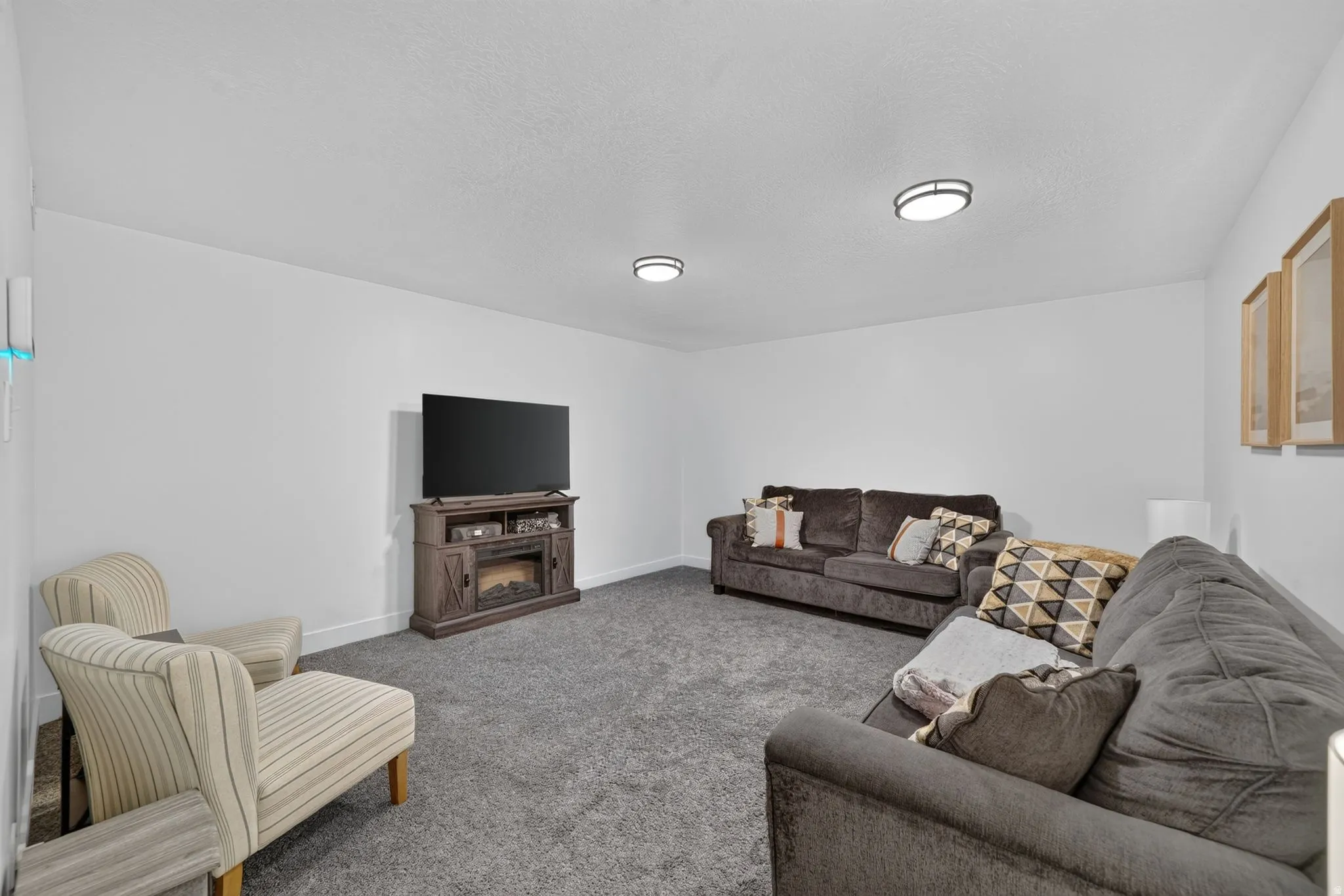 Plush carpet flooring, neutral white wall finishes, and integrated ceiling lighting