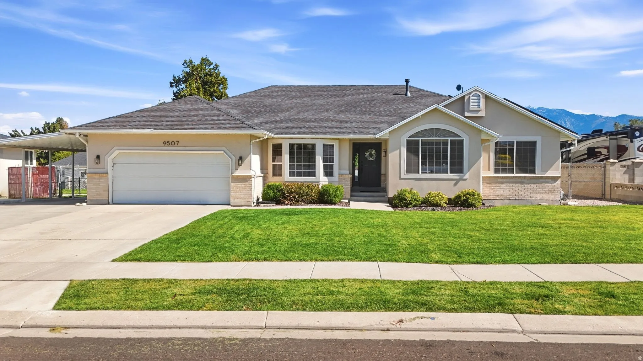 Single-story stucco exterior with stone accents, attached two-car garage, covered entry, and front landscaping