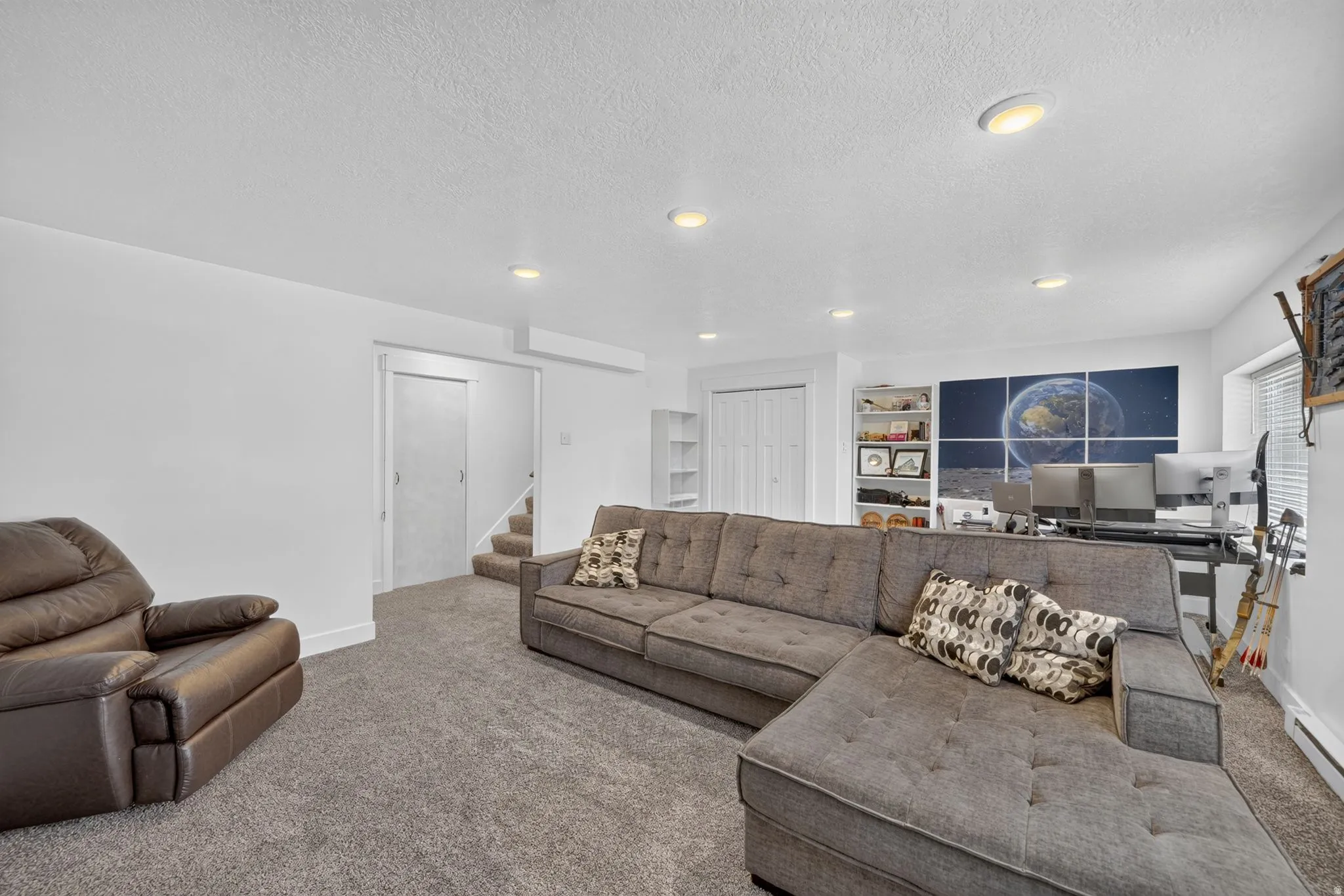 Recessed lighting illuminating a carpeted floor, built-in shelving, and white bi-fold closet doors